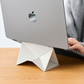 White foldable laptop stand supporting a laptop